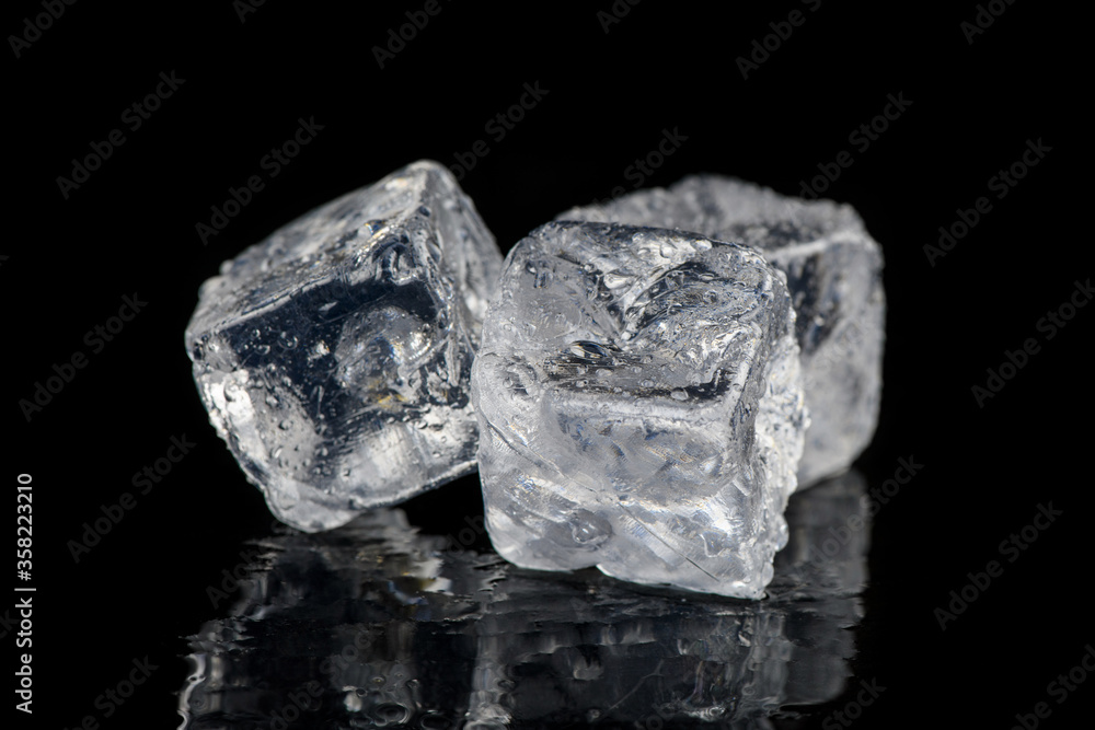 Ice cubes reflection on black table background Ice cubes reflection on black table background