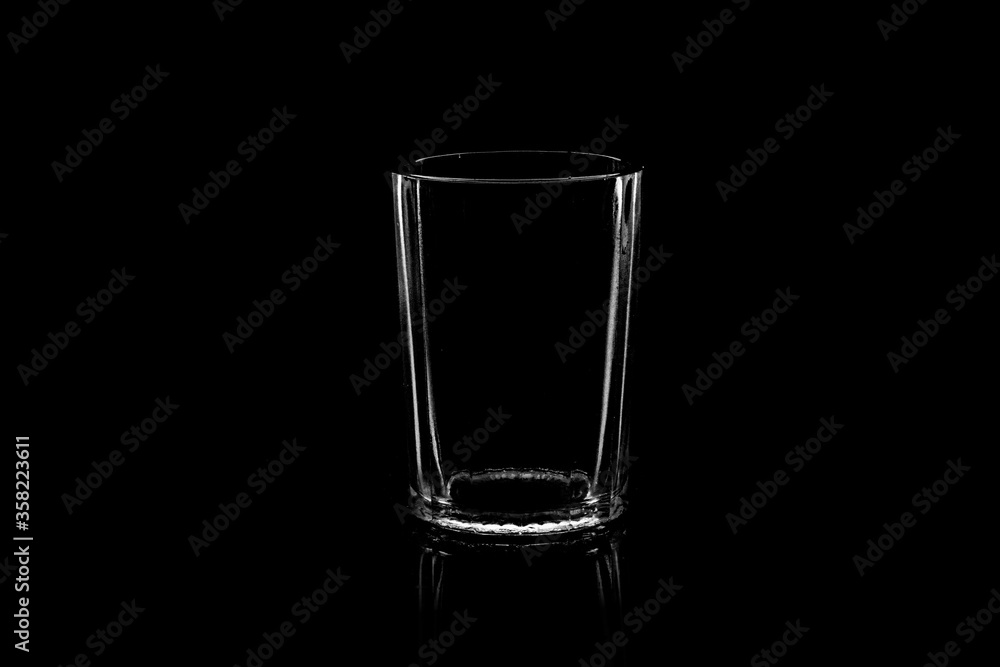 Low-key Studio Shot of a White silhouette of a faceted glass light glasses isolated on a black Background. Smooth lines and shapes. . Low-key Studio Shot of a White silhouette of a faceted glass light glasses isolated on a black Background. Smooth lines and shapes. .
