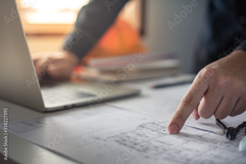 Architect working on blueprint. Architects workplace - architectural project, blueprints, ruler, calculator, laptop and divider compass. Construction concept. Blue print is fake only for stock photo.