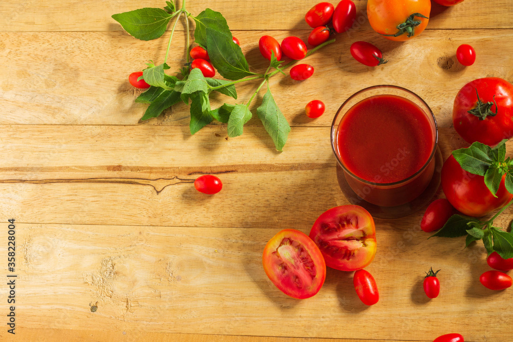 Top view, Tomato juice in clear glass On the wooden table Decorate with small and large fruits. Top view, Tomato juice in clear glass On the wooden table Decorate with small and large fruits.