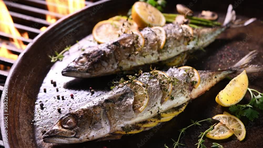 Grilled fish and various vegetables in iron plate Grilled fish and various vegetables in iron plate