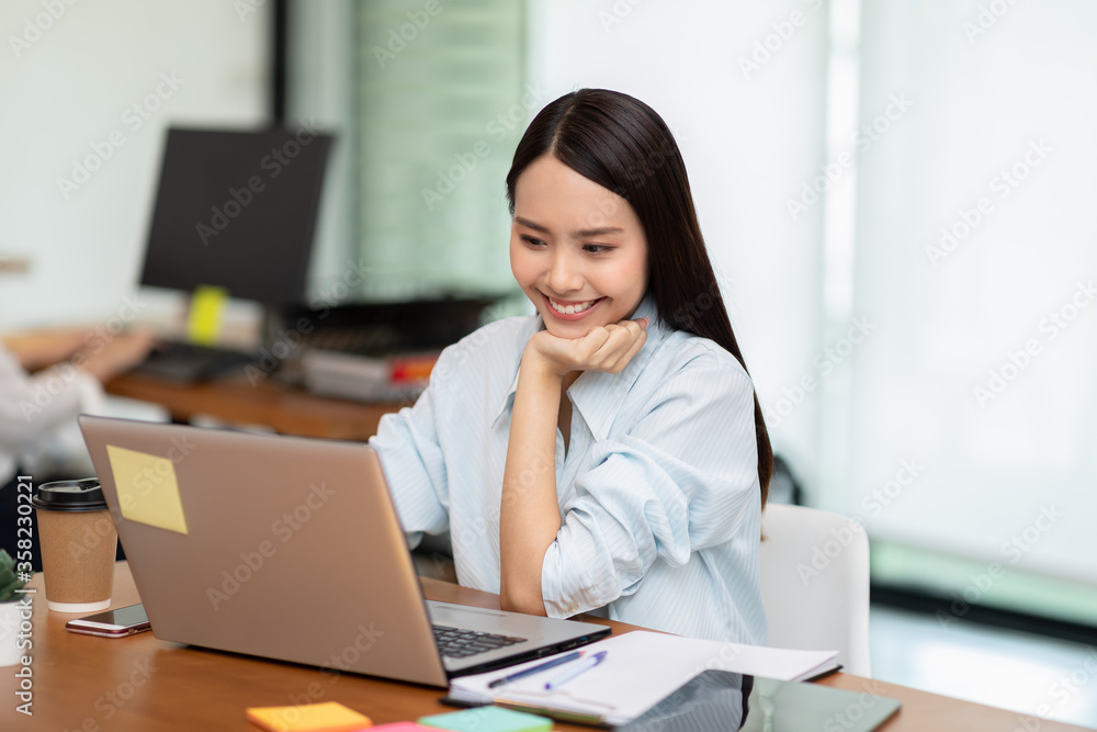 Happy Asian business woman looking laptop working and smile Happy Asian business woman looking laptop working and smile