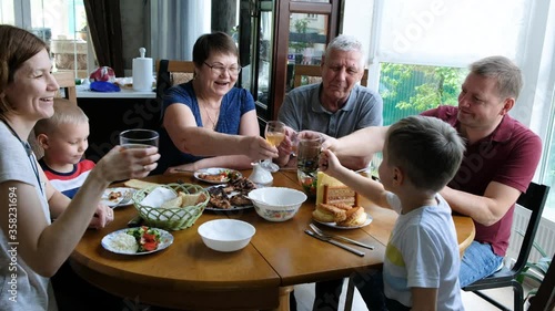 Big family meeting at the table. People Having fun, Communicating and Eating Indoors.