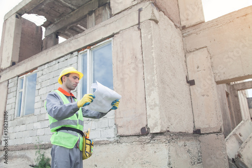 Construction worker with helmet holding blueprint.