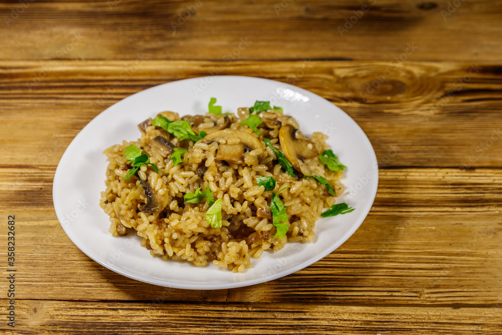 Tasty risotto with mushrooms on wooden table Tasty risotto with mushrooms on wooden table
