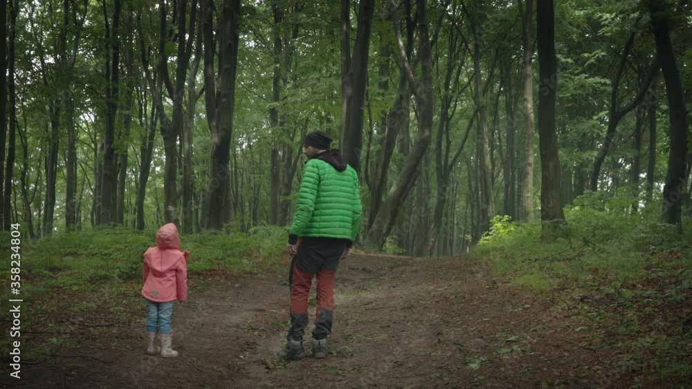 Father and daughter walking in the forest. Social distancing concept Father and daughter walking in the forest. Social distancing concept
