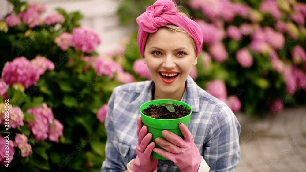 Housewife taking care of home plants and flowers. Mother plants. Mom in gardening. Happy woman in spring day. Attractive smiling european girl replanting flowers in garden. Taking out flower from pot. Housewife taking care of home plants and flowers. Mother plants. Mom in gardening. Happy woman in spring day. Attractive smiling european girl replanting flowers in garden. Taking out flower from pot.