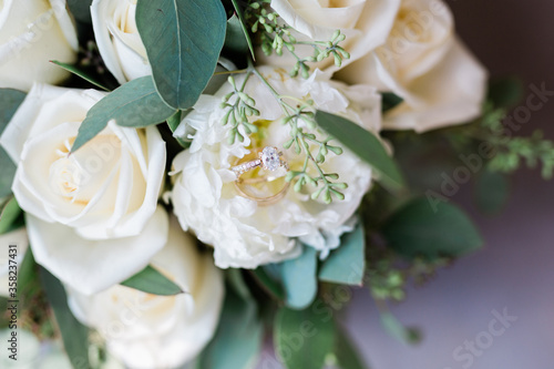 Wedding and engagement ring nestled in brides wedding bouquet