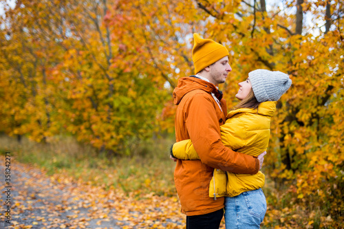 cute couple embracing over autumn forest background