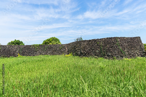 Volcanic stone wall and green field of Seongeup Folk Village. photo