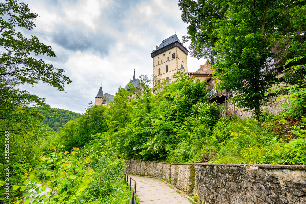 Famous medieval gothic castle Karlstejn on top of the hill. Beautiful stronghold is built by king Charles IV. Historical national heritage of Czech Republic is placed near Prague city. Cloudy weather Famous medieval gothic castle Karlstejn on top of the hill. Beautiful stronghold is built by king Charles IV. Historical national heritage of Czech Republic is placed near Prague city. Cloudy weather