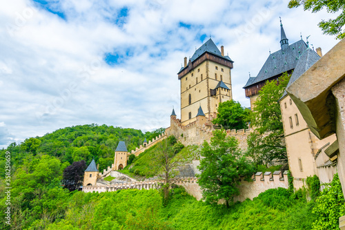 Famous medieval gothic castle Karlstejn on top of the hill. Beautiful stronghold is built by king Charles IV. Historical national heritage of Czech Republic is placed near Prague city. Cloudy weather