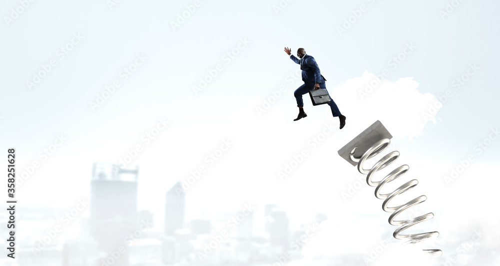 Businessman jumping on springboard . Mixed media Businessman jumping on springboard . Mixed media