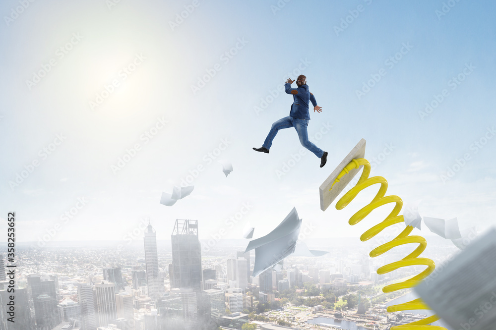 Businessman jumping on springboard . Mixed media Businessman jumping on springboard . Mixed media