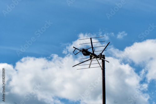 TV antenna on the roof against the blue sky and clouds © pro2audio