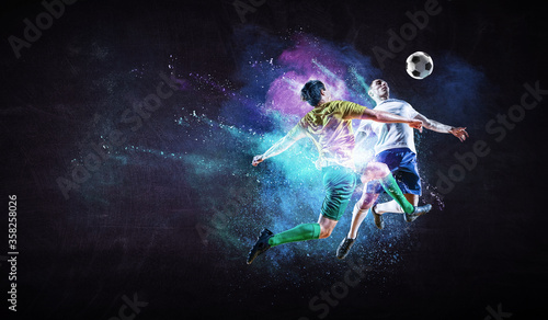 Boys playing soccer hitting the ball © Sergey Nivens