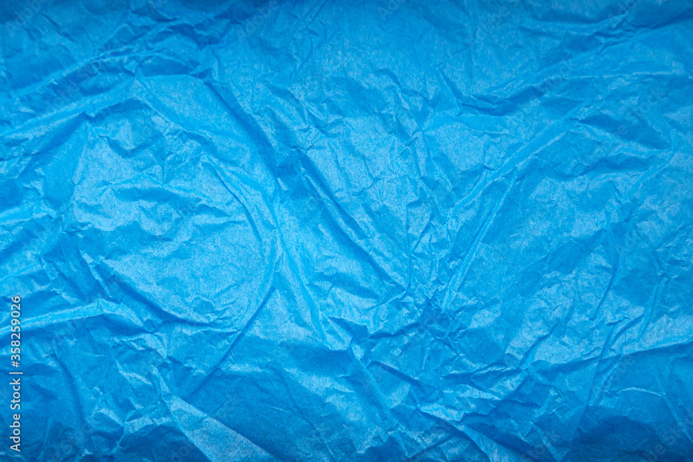Obraz premium Crumpled blue wrapping paper as abstract background, texture
