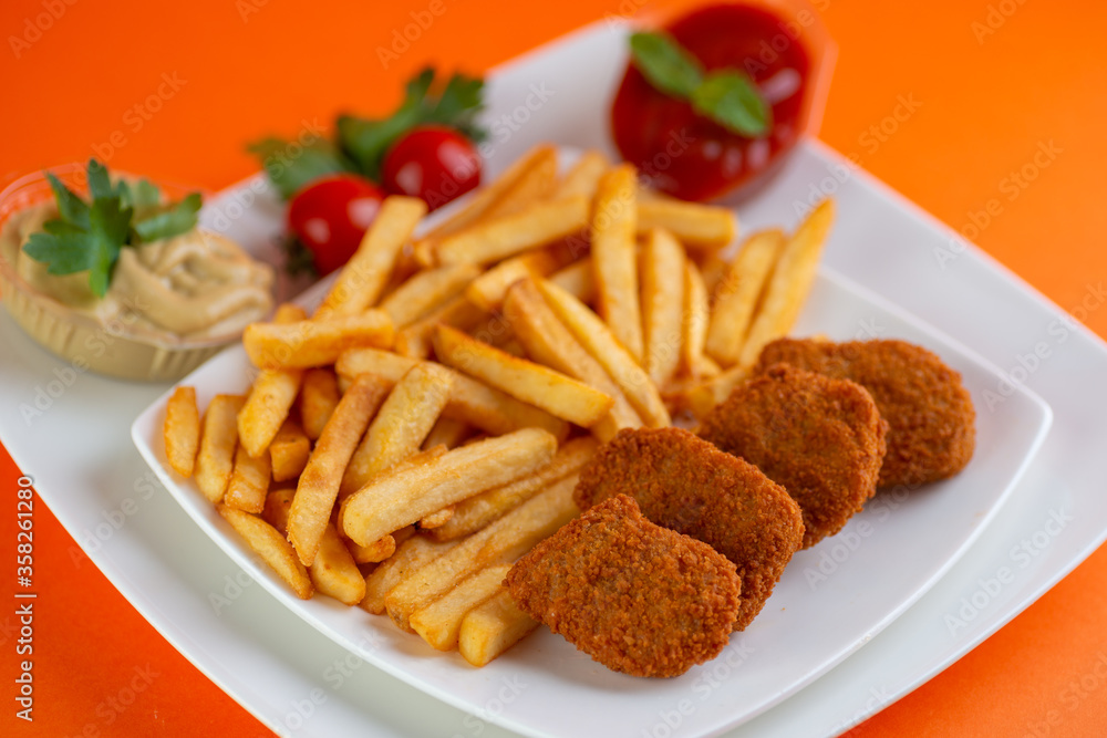 Fried chicken nuggets with fries and tomato ketchup. Fried chicken nuggets with fries and tomato ketchup.