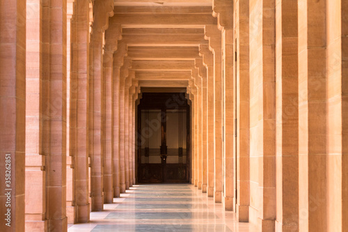 Sand stone corridor with pillars leading to a door. Rajasthan   india Umedbhawan