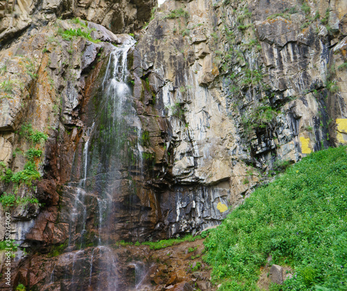Beautiful waterfall in the mountains. Eco Tourism, eco travel. Mountain landscape, valley of mountains. Waterfall among stones and rocks. © Сергей Дудиков