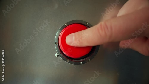 Finger presses the big red button 