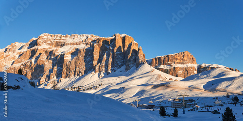 Winter panoramic view of a rocky mountain range at sunset near Val Gardena ski resort in Italy.