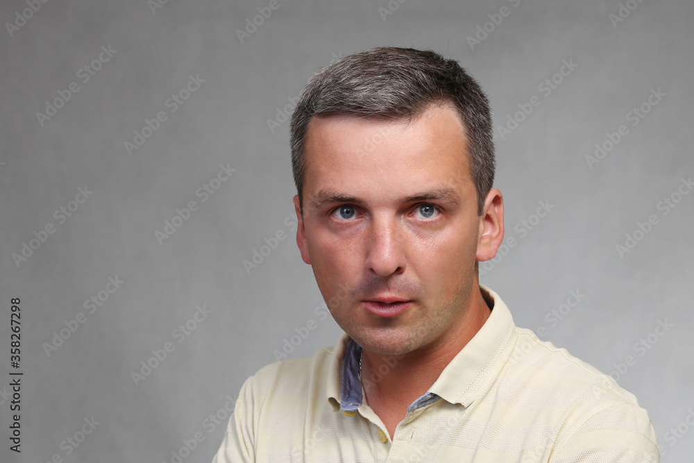 Portrait of an aggressive man on a gray background. Portrait of an aggressive man on a gray background.