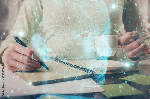 Double exposure of writing hand on background with brain hologram. Concept of learning.