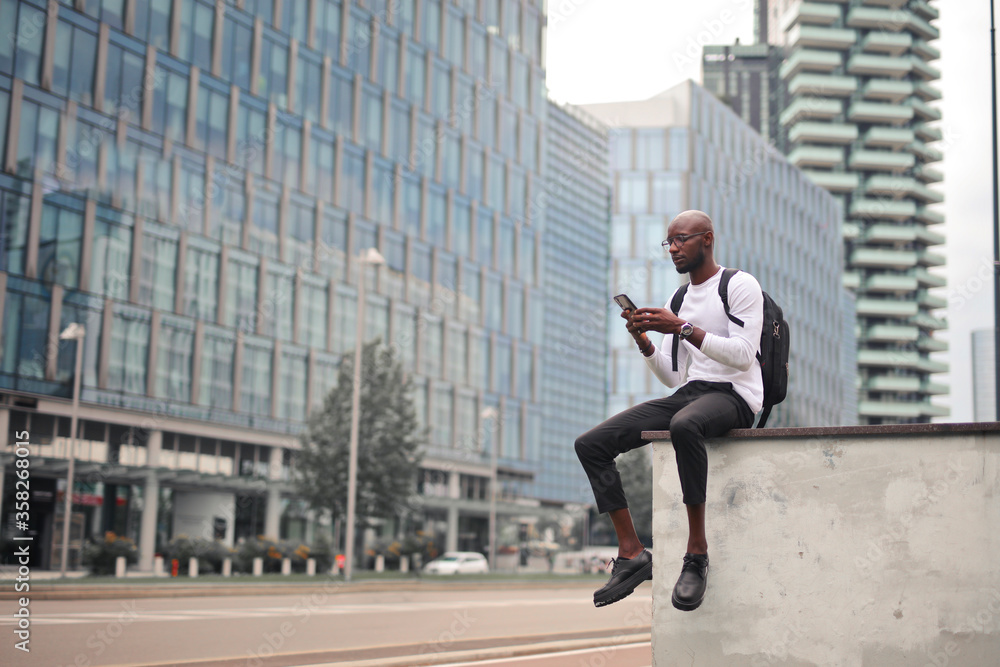 young man writes with smartphone in the city young man writes with smartphone in the city