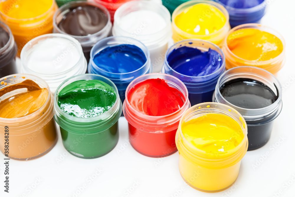 Plastic jars of colored paints on white background Plastic jars of colored paints on white background