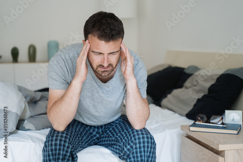 Restless man waking up early with headache after rough night Fototapet