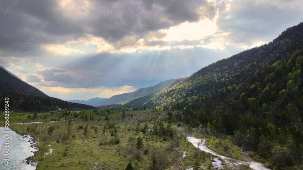 Aerial flying through a river valley and sunbeams hitting the mountain side Aerial flying through a river valley and sunbeams hitting the mountain side