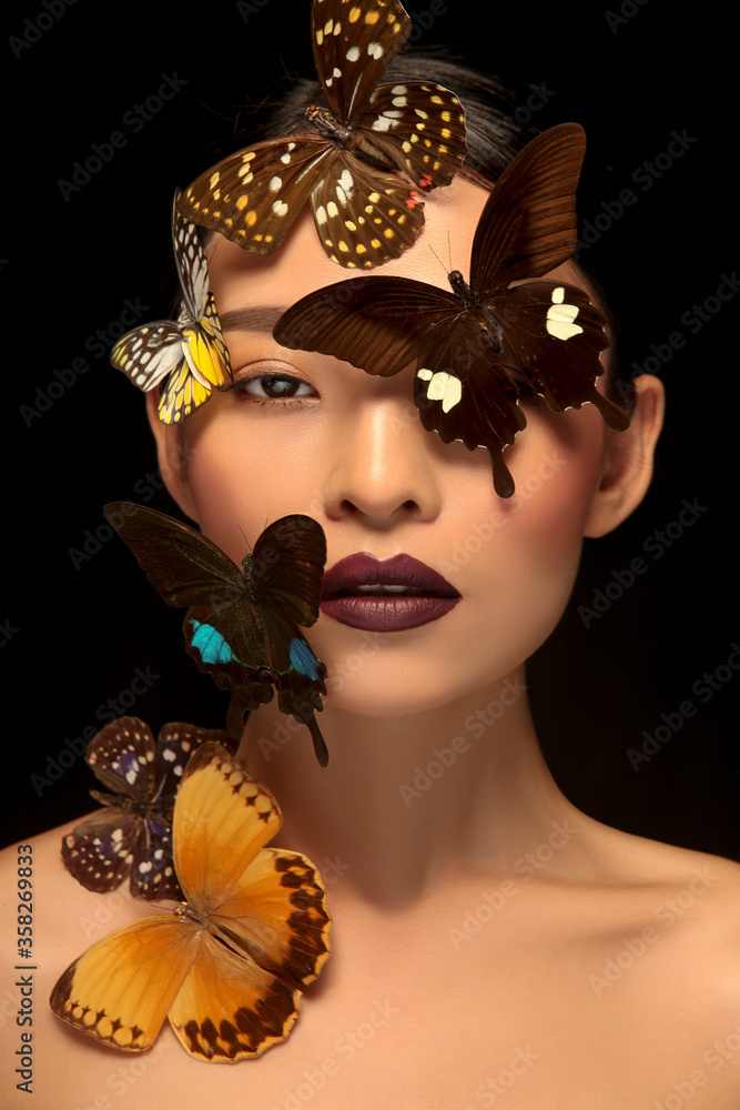 Asian woman decorating makeup face with butterfly taking makeup photo