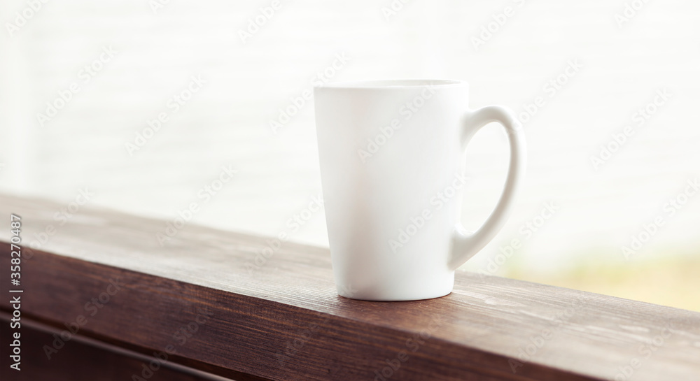 The cup of coffee on the wooden handrail
The cup of coffee on the wooden handrail