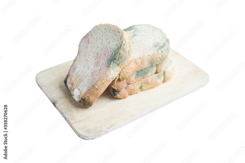 Obraz premium Moldy Whole wheat bread loaf on cutting board over white background.