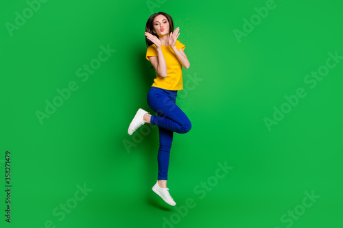 Full length body size view of her she nice attractive lovely lovable funky cheery slim fit girl jumping having fun sending air kiss isolated bright vivid shine vibrant green color background