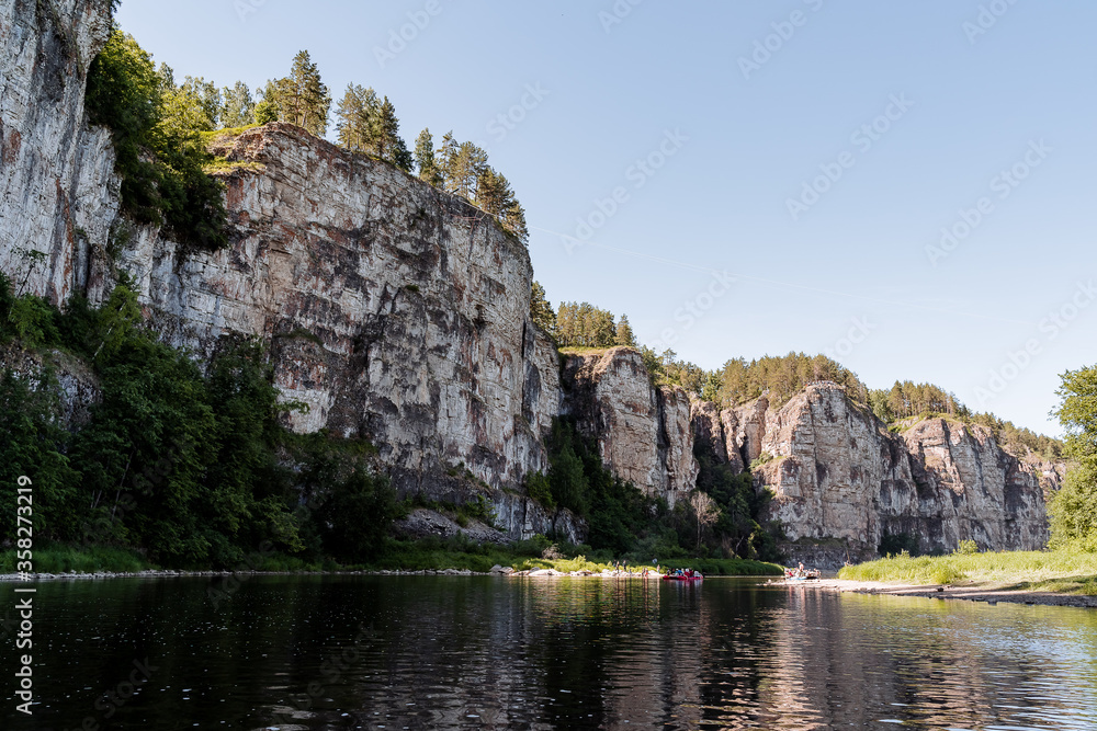 summer day on the river with rocky banks, blue sky, mountains, forest, landscape, river AI
