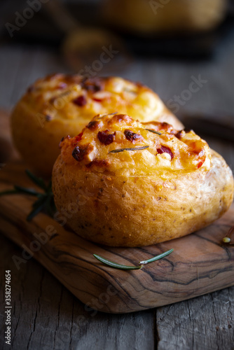 Baked potatoes stuffed with cheese, vegetables and rosemary