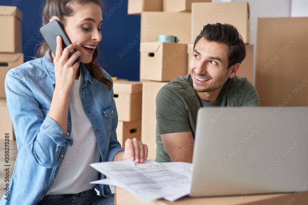 Cheerful couple getting things done via phone Cheerful couple getting things done via phone