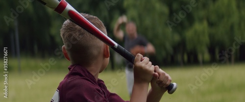 Photography MED Father and son playing baseball in the park on a rainy day