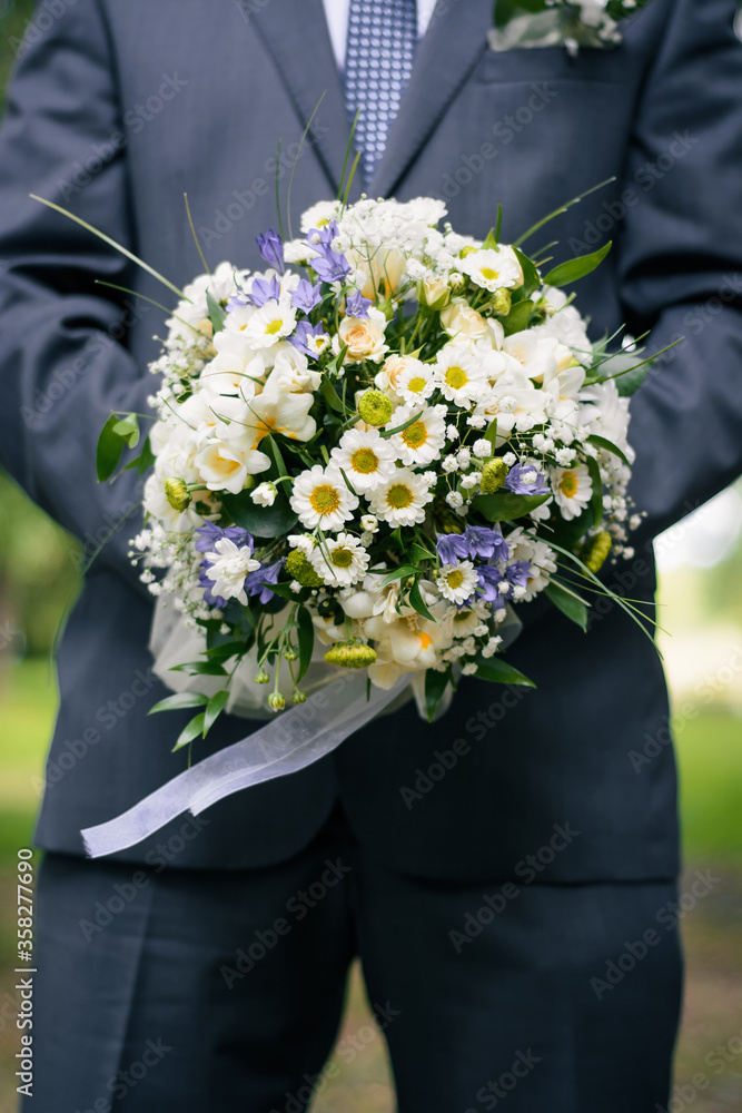 wedding bouquet in the hands of the groom wedding bouquet in the hands of the groom