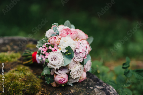 wedding flower bouquet lies on the stump