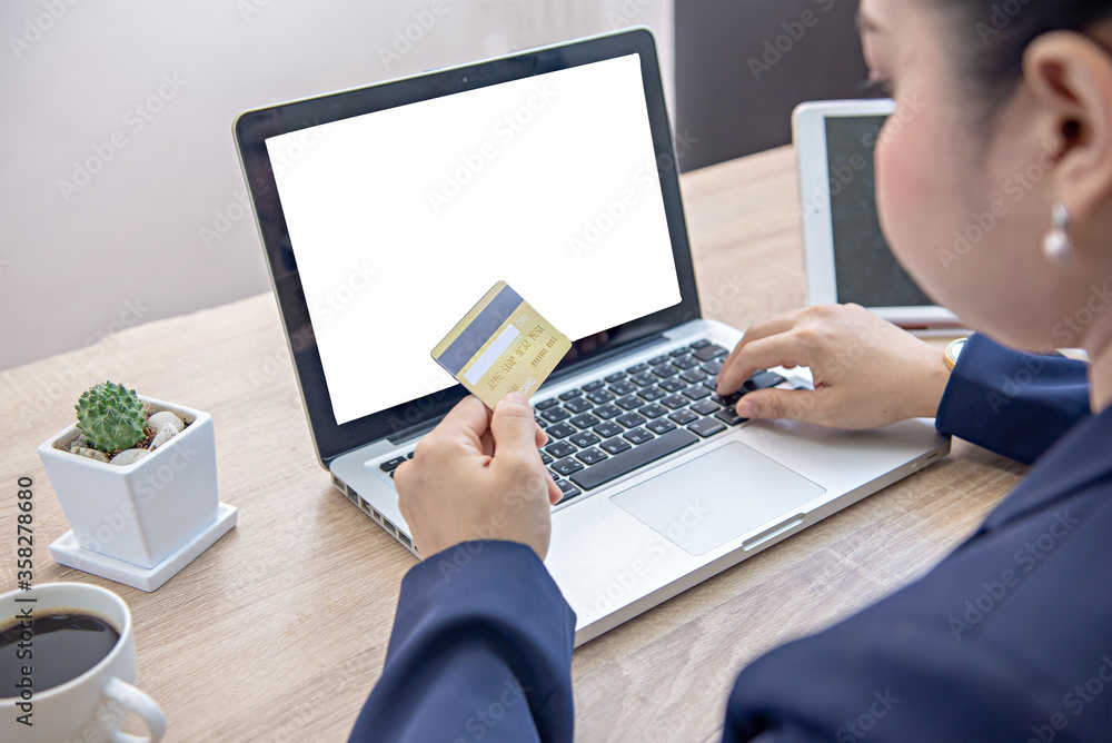 Hands holding plastic mock up credit card and using laptop. Online shopping concept. Hands holding plastic mock up credit card and using laptop. Online shopping concept.