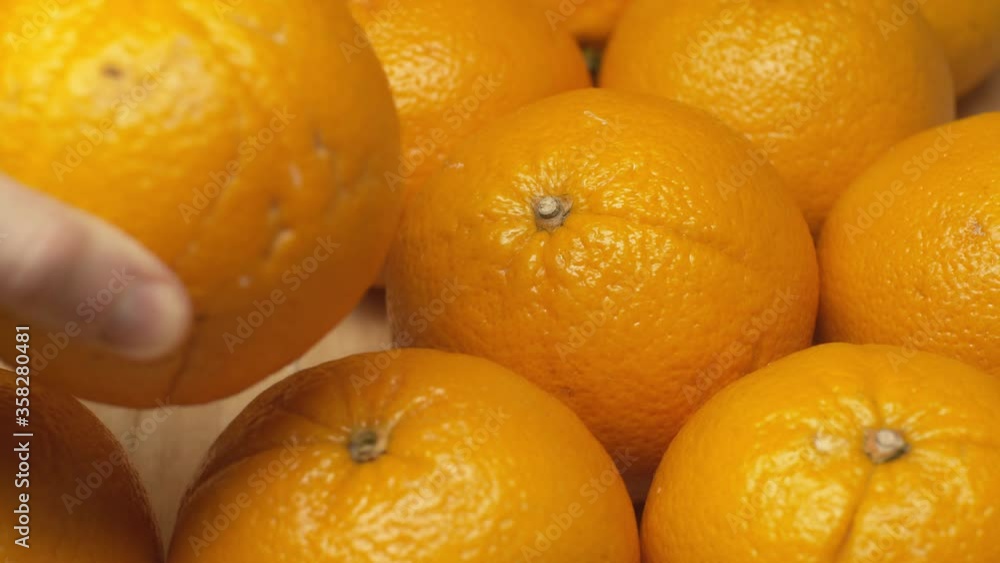Cropped view of man taking and putting orange on wooden surface Cropped view of man taking and putting orange on wooden surface