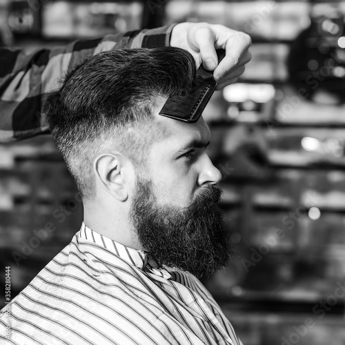 Bearded man making haircut to look perfect. New perfect style. Beard styling and cut.