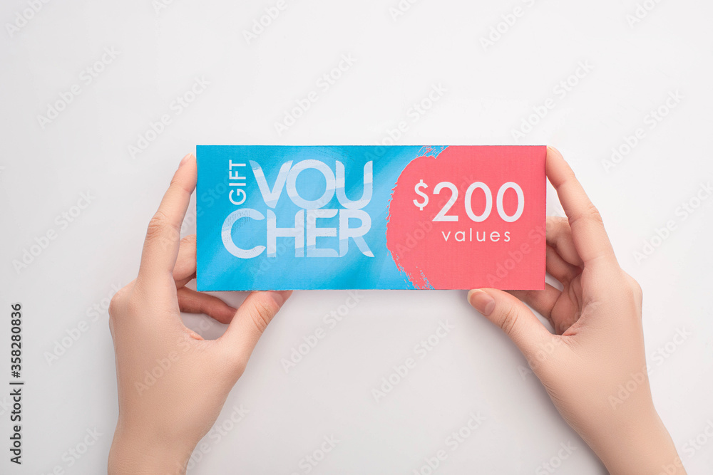 Top view of woman holding gift voucher with 200 values sign on white background Top view of woman holding gift voucher with 200 values sign on white background