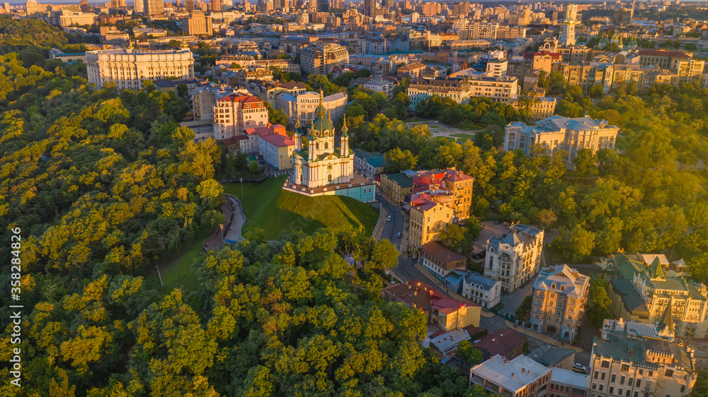 Andriyivskyy Descent and St Andrew's Churchin Kyiv ( Kiev ) city the capital of Ukraine in eastern europe. Beautiful sunset light on historical hills. Top aerial drone panoramic view from above. 