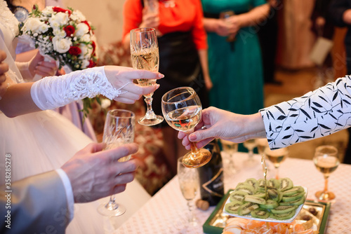 people clink glasses of champagne at a wedding in a restaurant