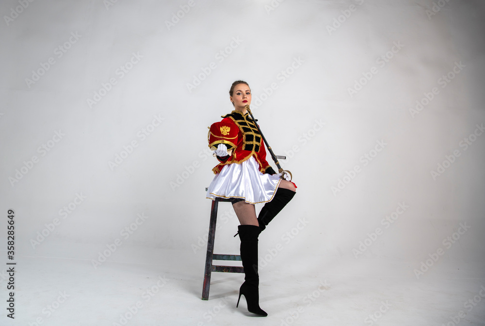 Fototapeta premium beautiful girl in a red antique hussar costume posing on a white background
