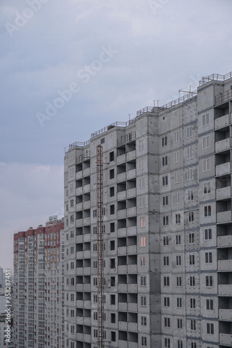 Large construction site on a background of blue sky. Brick  panel apartment building. Industrial theme for design
